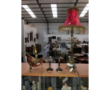 A brass based table lamp, a pair of candle stands and a small copper coal helmet