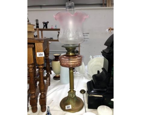 A Victorian brass column oil lamp with pink glass font