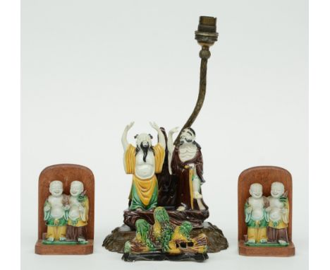 A pair of Chinese sancai mud-men and a brush holder, 19thC; added a ditto group on a wooden base mounted into a lamp, H 7 - 3