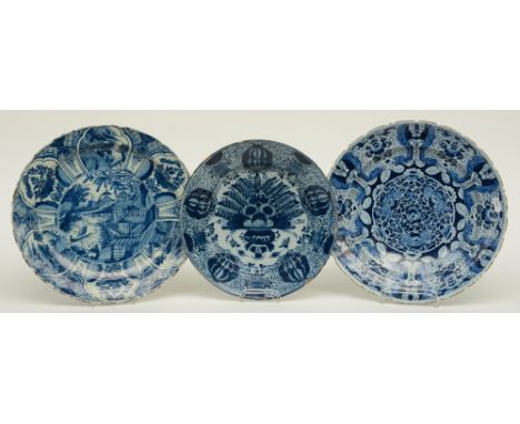 Three 18thC blue and white decorated Dutch Delftware plates: one in the Ming style and marked LVE (De metalen Pot); one marke