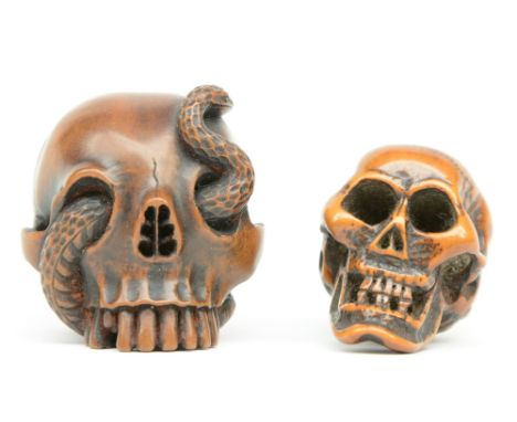Two Japanese boxwood katabori netsuke in the form of a human skull (one with a snake on top), Edo-period, H 3,8 - 3,3 cm
