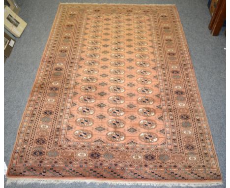 Lahore 'Bukhara' rug, Pakistan, the faded peach field with columns of quartered guls enclosed by multiple borders, 184 by 126