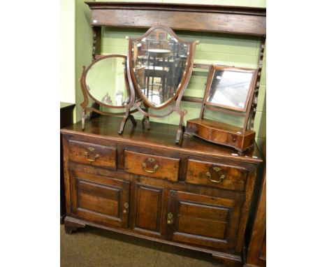 An 18th century oak enclosed dresser and rack, with two shelves and shaped end supports, the base with three deep drawers abo