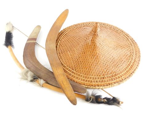 Tribal Art.  An Australian Aboriginal boomerang painted in cream, 51cm wide, another boomerang, a bow and arrow, and a coolie