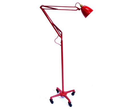 An industrial floor lamp, later painted red, on egg shaped base with castors.