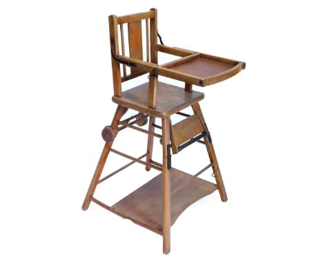 An early 20thC beech child's high chair, with adjustable shelf and a concave under tier.