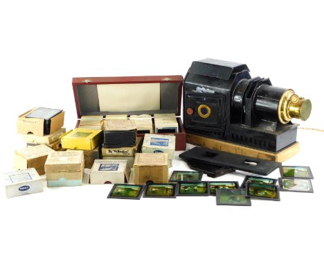 An ebonised and brass magic lantern and various magic lantern slides, mainly boxed, to include The Boy Scouts, British Navy, 