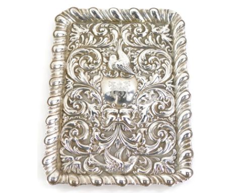 An Edwardian embossed rectangular dressing table tray, engraved centrally with a monogram, decorated overall with birds, flow