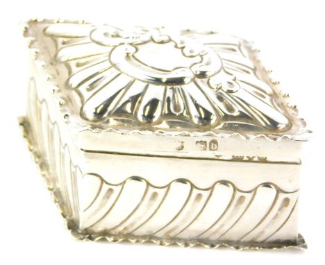 A late Victorian lozenge shaped trinket box, embossed with scrolls, within a shaped border and base, the hinged lid enclosing