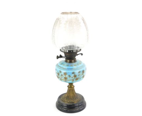 A Victorian oil lamp, with a floral etched shade, a blue glass reservoir decorated with flowers, on a gilt brass support and 