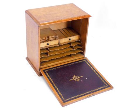 An Edwardian and oak stationery box, the hinged fall front enclosing a fitted interior with pigeon holes, drawers, and a maro