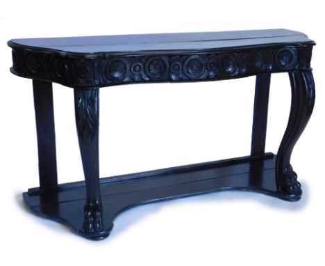 An early 19thC ebonised oak console table, the serpentine shaped top with a moulded edge, above a carved frieze with a single