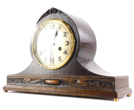 An early 20thC oak mantel clock, the silvered dial with Arabic numerals on bun feet, 43m wide.