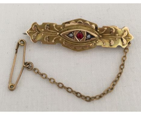 A Victorian hallmarked 9ct gold brooch set with ruby and seed pearls. Complete with safety chain. Hallmarked Chester 1899. Ap