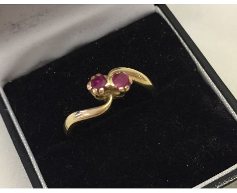 A vintage 18ct gold dress ring set with 2 rubies. Cross over shank. Size P 1/2 