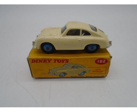 A vintage boxed Dinky Toys die-cast Porsche 356A Coupe with windows, comprising of cream body with dark blue hubs (No 182)