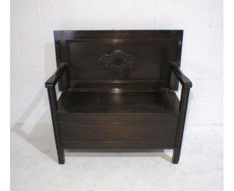 An oak monk's bench with lift up seat and carved detailing, marked 'Raleigh Furniture', length 100cm, depth 50cm, height 70cm