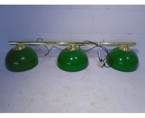 A set of vintage pool table lights with three enamel shades