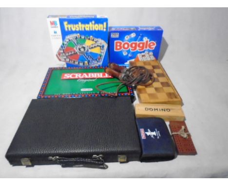 A small collection of various games including  Boggle, Scrabble, chess set, backgammon, domino, vintage skipping rope, playin