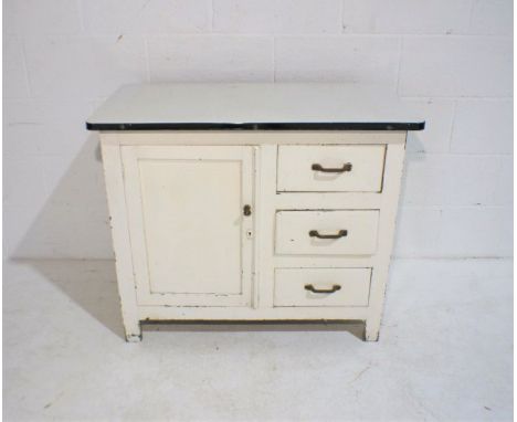 A vintage white painted cupboard with three drawers and enamel top, length 92cm, depth 46cm, height 77cm.