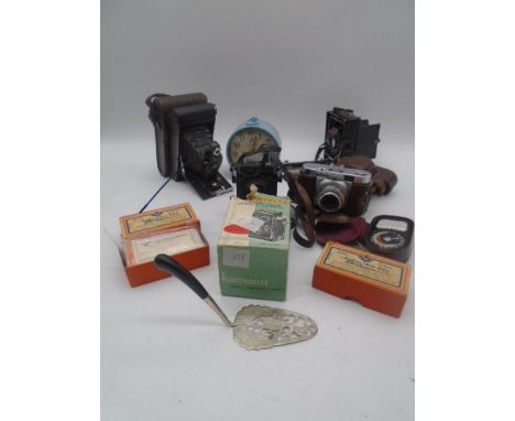 A small collection of cameras including a Voightlander Vito B, alarm clock etc.