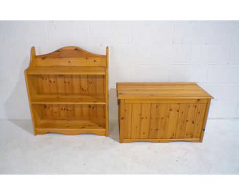 A pine freestanding bookshelf along with a pine trunk.