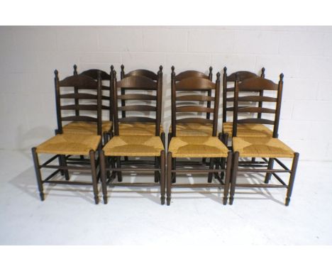 A set of eight oak ladder-back chairs with rush seating.