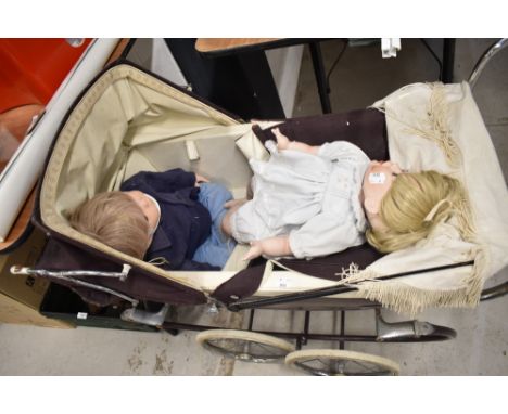 A Silver Cross Pram having double spoke wheels on suspension frame, brown body and hood with cream interior containing two mo