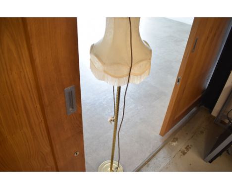 A brass standard lamp with shade