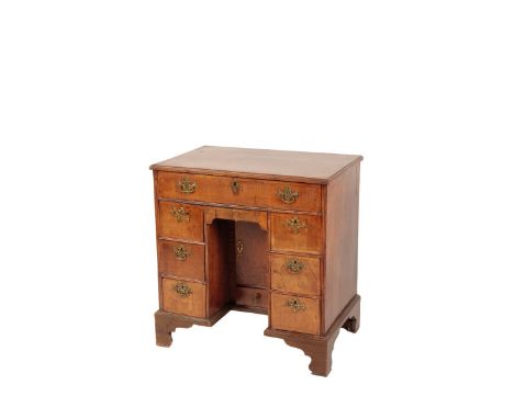 A GEORGE I WALNUT AND FEATHERBANDED KNEE HOLE DESK 18th century with alterations. the moulded rectangular top above one friez