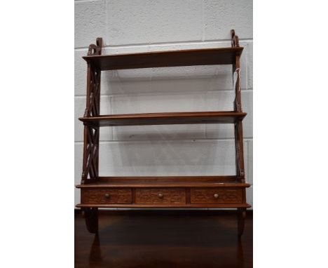 A wall mounted shelf and drawer unit in an exotic hard wood