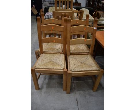 A set of four modern beech ladder back chairs having rush seats