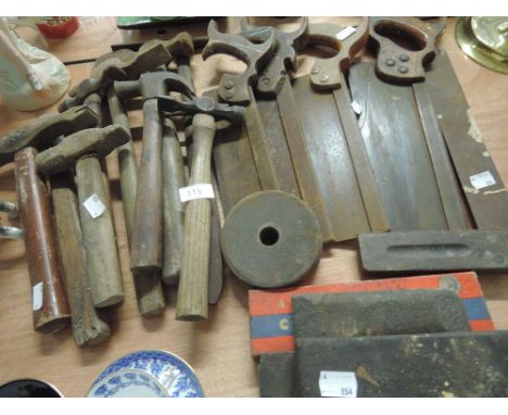 A selection of vintage hand tools including hammers, saws and sharpening stones