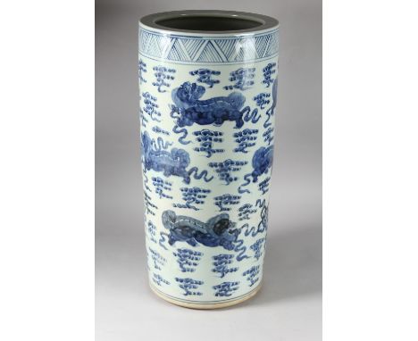 A VERY LARGE CHINESE BLUE AND WHITE PORCELAIN STICK STAND, decorated with dogs of fo and stylised clouds, 59.5cm high.