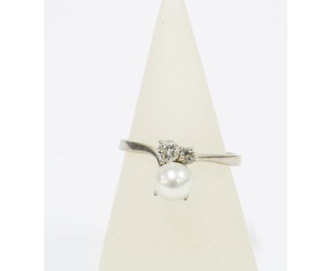 Pearl and diamond ring, the large cultured pearl offset by two brilliant cut diamonds, on a plain white metal shank with indi