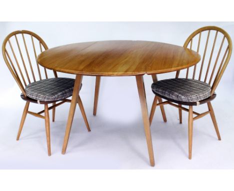 AN ERCOL LIGHT ELM AND BEECHWOOD DROP LEAF DINING TABLE 113cm wide together with a set of six matching dining chairs consisti