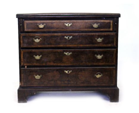 A 19TH CENTURY GEORGIAN STYLE WALNUT VENEERED CHEST of four long graduated drawers with brass swan neck handles and having a 