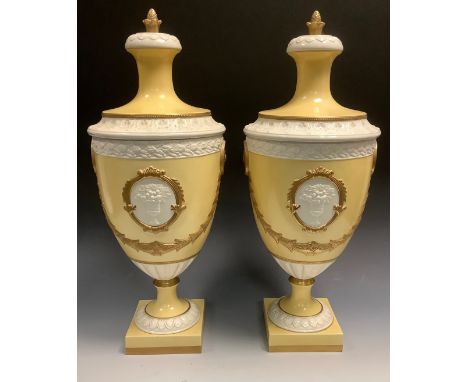 A pair of Italian urns and covers, in relief with oval cartouches, in relief with urns and flowers, gilt harebell swags, on a