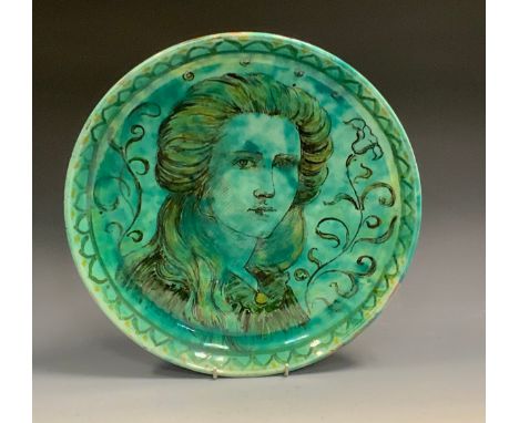 A Della Robbia charger, painted by Harold Rathbone, with a portrait of Enid Woodhouse, in black, picked out in yellow in a mo