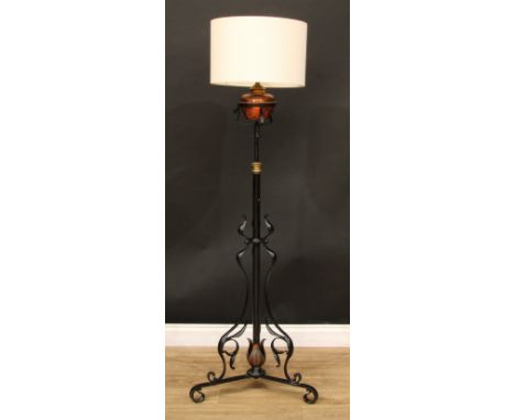 An Arts &amp; Crafts wrought iron, copper and brass standard lamp, in the manner of W.A.S Benson, triform base with sinuous o