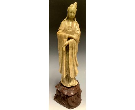 A Chinese celadon soapstone carving, of Guanyin, well-carved with a serene face, wearing flowing robes and holding a scroll, 