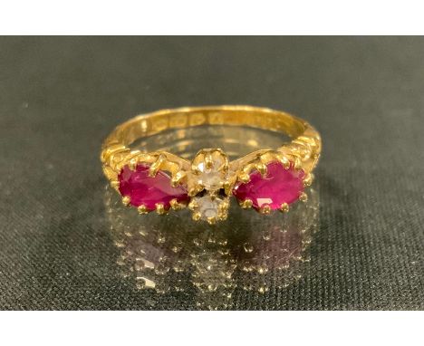 An Edwardian ruby and diamond ring, set with a pair of old cut diamonds between pear drop vibrant pinky red rubies, 18ct gold