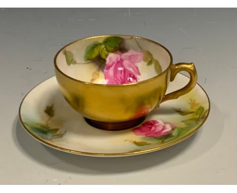 A Royal Worcester cabinet cup and saucer, decorated with roses, the exterior in gilt, crown and circle mark date code for 191