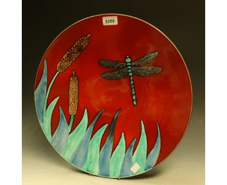 A contemporary Poole charger, decorated with a dragonfly on a red ground, 40cm diam, painted mark, boxed
