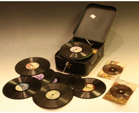 An early century portable clockwork phonograph record player, possibly Bing, black suit case effect outer case, green texture