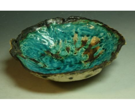 A fabric moulded stoneware bowl, possibly Ewen Henderson, of irregular form, glazed in turquoise on a textured ground, 22cm d