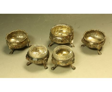 A early Victorian silver salt, embossed with foliate scrolls, London 1939; a pair of Victorian silver table salts, tripod fee