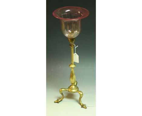 A brass table lamp, attributed to WS Benson, brass column, tripod feet, cranberry glass shade, 44.5cm high overall