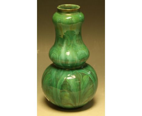 A Della Robbia slender double gourd vase, slip glazed in green, incised with anthemion leaves and scrolling bands of foliage,