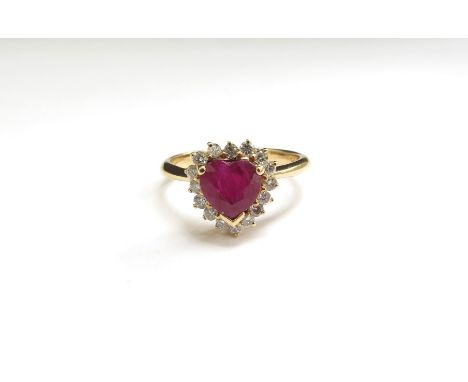 A heart shaped ruby and diamond ring, the central ruby framed by 16 small diamonds, shank stamped 18k. Size N, 3.6g 